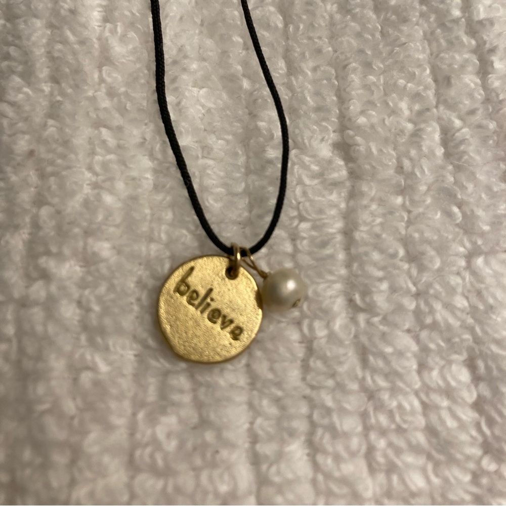 Believe necklace $ with gold tone tag and small pearl.